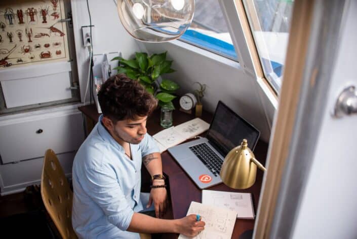 Hombre escribiendo en un cuaderno en su escritorio