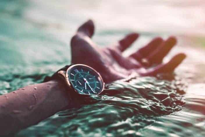  Foto recortada del brazo con reloj en el mar