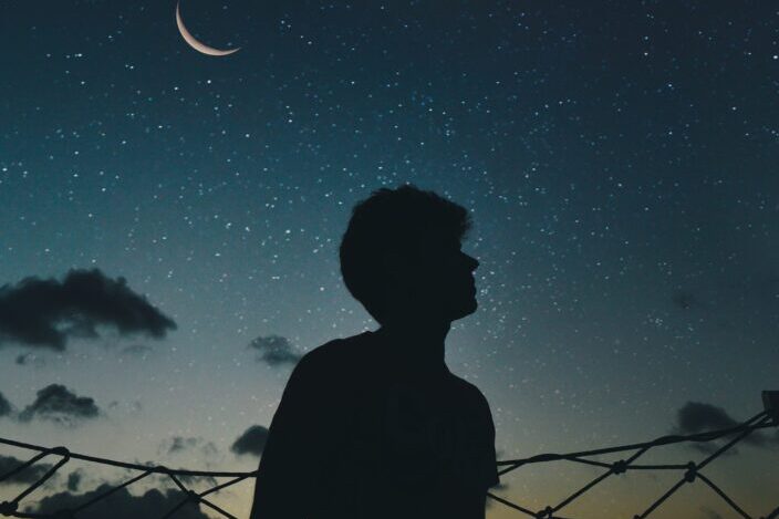 silueta de un hombre mirando un cielo estrellado