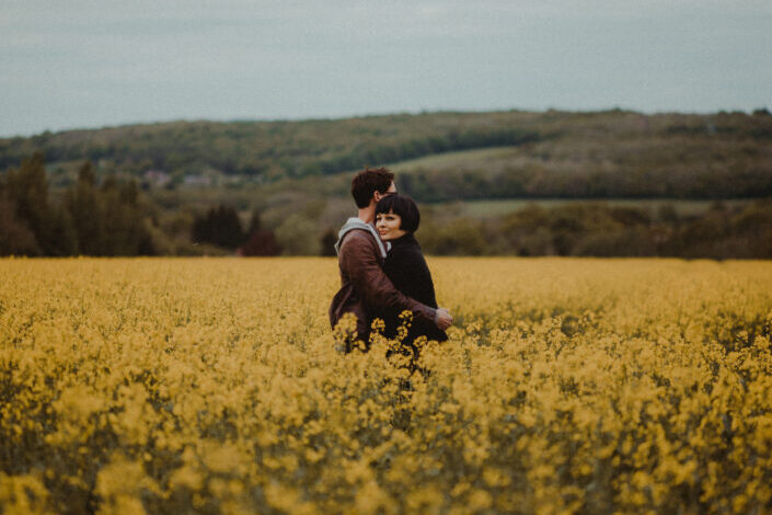 pareja abrazándose en medio de flores doradas