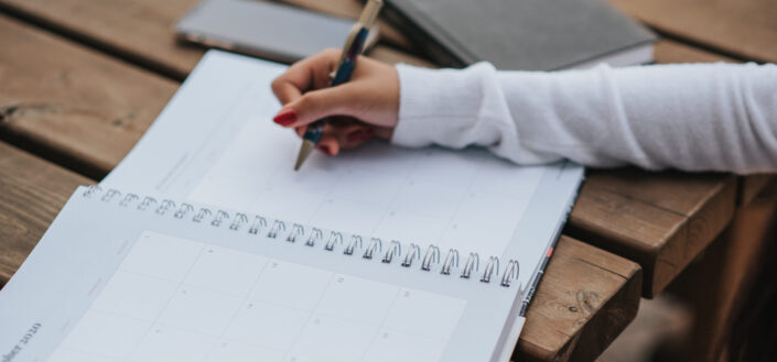 Mujer de cultivo haciendo horario en planificador