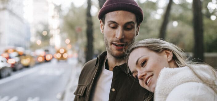 Pareja sonriente teniendo cita romántica en las calles de la ciudad