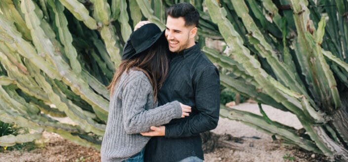 pareja riendo en un jardín de plantas gigantes