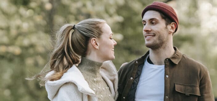 Pareja de adultos jóvenes tener conversaciones mientras camina fuera
