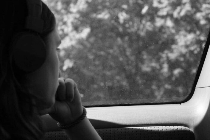 Mujer sola mirando afuera a través de la ventanilla del coche