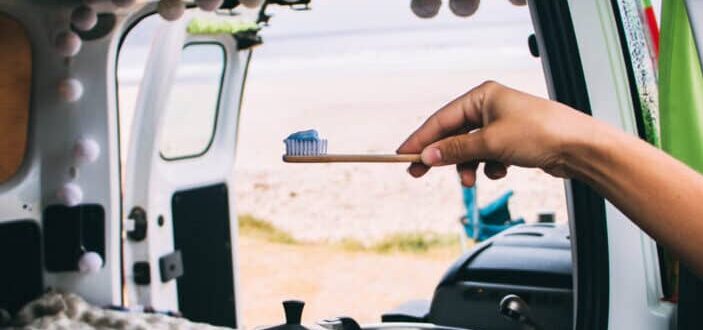  A traveler getting ready for a hygiene routine with toothbrush and toothpaste.