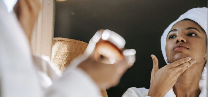  A woman applying an ointment to her neck.