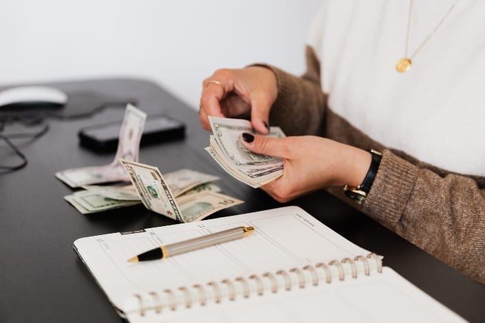 mujer contando su dinero haciendo presupuesto