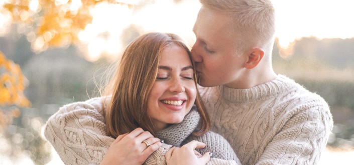 hombre besando a su chica en la cabeza mientras se abraza