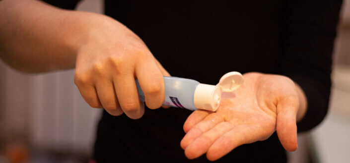 Man pouring a disinfectant into his left hand.