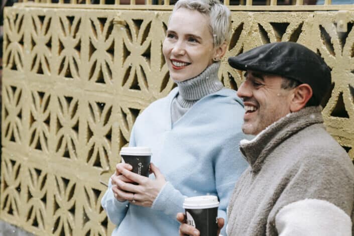Hombre y mujer charlando mientras bebe café afuera en un clima frÃo