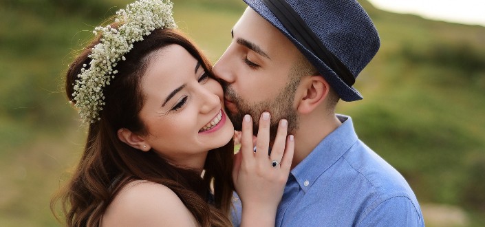 dulce hombre besando a su chica en las mejillas