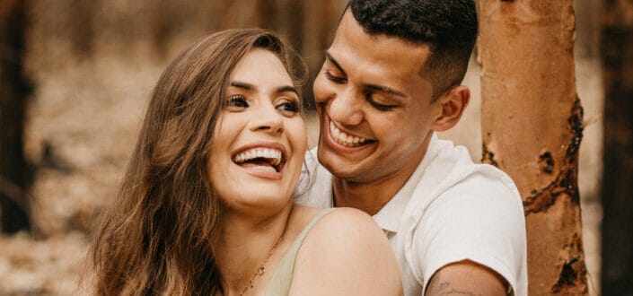 feliz dulce pareja sentada junto a un árbol