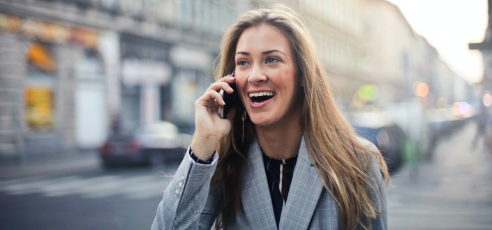 Mujer caminando por la calle mientras habla con alguien por su teléfono